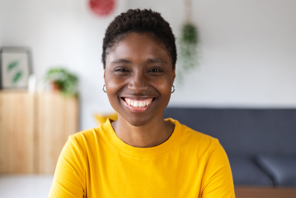 Portrait screen view of smiling millennial african woman on video call at home